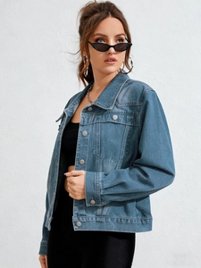 Detail of blue-grey washed denim jacket with vintage metal buttons and pocket seams