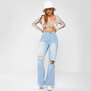 Women's light blue high-waisted wide-leg ripped jeans with raw hem and distressed details