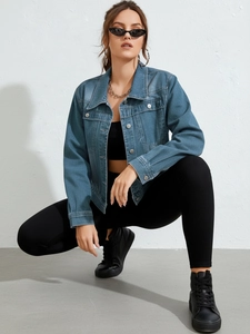 Detail of blue denim jacket showing metallic buttons and washed texture in street style