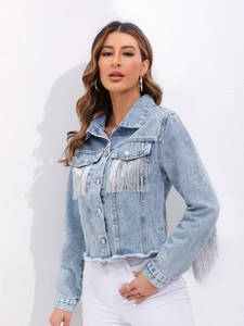 Dettaglio della giacca in denim azzurro con frange argentate su maniche e tasche