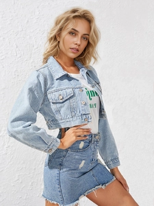 Detail of light blue washed denim jacket with metal buttons and frayed denim skirt outfit