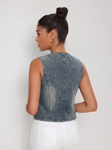 Back view of retro washed denim vest with structural stitching and distressed blue finish