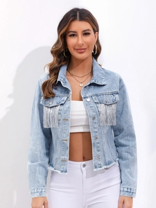 Dettaglio della giacca di jeans azzurra con frange argentate e finitura con orlo a vivo