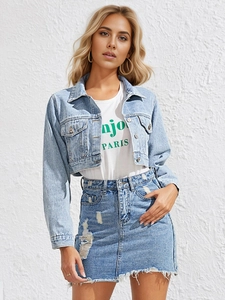Detail of light blue washed denim jacket with distressed fringe and raw hem edges