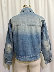 Back view of blue denim jacket with vintage wash effect and horizontal shoulder seam detail