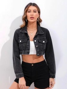 Close-up of washed black denim jacket texture with metal buttons and chest pocket details