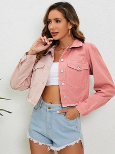 Détail d'une veste courte bicolore avec ourlet effiloché et texture sur les poches avant