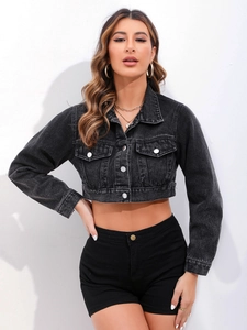 Detailed close-up of a vintage black cropped denim jacket with silver metal buttons