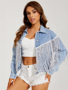 Detail of light blue denim jacket featuring long white fringes on front and sleeves