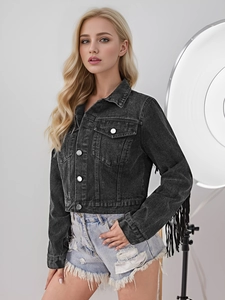 Gros plan sur une veste en jean noir délavé avec de longues franges sur les manches