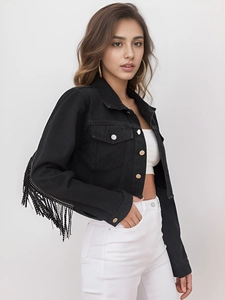 Detail of black denim jacket featuring long fringe tassels on sleeves and metal buttons