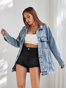 Détail d'une veste en jean bleu clair oversize avec texture usée et poches de poitrine