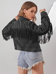 Détail du dos d'une veste en jean noir délavé avec de longues franges au style bohème