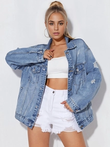 Detail view of oversized light blue denim jacket featuring distressed rips and drop shoulders