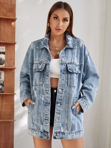 Détail de la veste en jean oversize bleu clair avec des déchirures et finitions usées