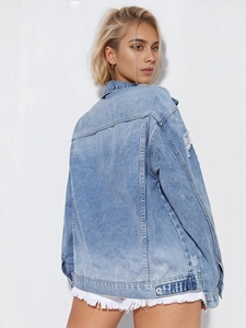 Close-up of light blue denim jacket featuring distressed ripped details on the back sleeves
