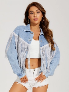 Detailed close-up of light blue denim jacket with elegant silver fringe on the sleeves