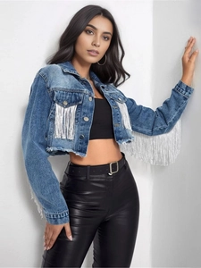 Dettaglio della giacca di jeans blu chiaro con frange argentate e orlo sfrangiato