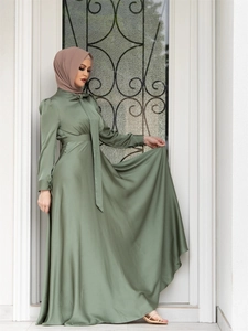 Detailed view of olive green satin long-sleeve dress with elegant neck tie accent