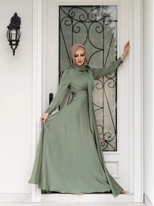 Detail of elegant sage green satin maxi dress with high neck and long sleeves