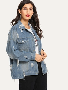 Detailed view of women's distressed denim jacket with heavy ripping and frayed edges