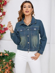 Detail of slim fit denim jacket showing vintage wash texture and metallic button closure