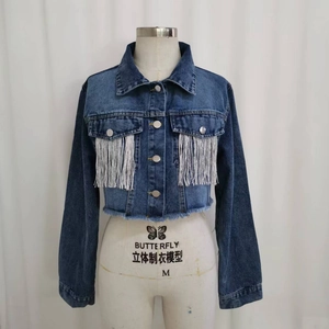 Dettaglio giacca di jeans blu con frange argentate e orlo sfrangiato effetto invecchiato
