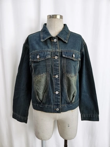 Detailed view of dark blue vintage denim jacket with chest pockets and washed texture