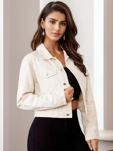 Detail of cropped cream corduroy jacket featuring flap pockets and silver buttons
