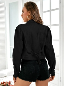 Rear view of black cropped denim jacket featuring puff sleeves and back buckle details