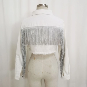 Dettaglio della giacca di jeans bianca con lunghe nappe argentate e orlo sfrangiato grezzo