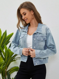 Detail of light blue washed denim jacket with metal buttons and flap chest pockets