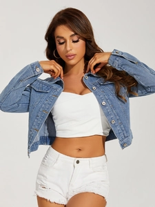 Detail of light blue cropped denim jacket with silver buttons and chest flap pockets