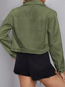 Rear view of cropped army green denim jacket with metallic buttons and black fringe shorts