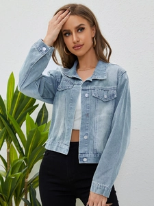 Close-up of light blue cropped denim jacket featuring metallic buttons and chest pockets