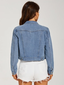 Detail view of the back seams and metal buttons on a light blue cropped denim jacket