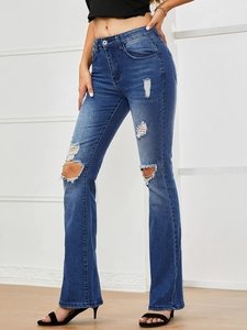Detail of high waisted flare jeans with ripped knee design and dark blue wash