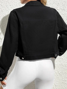 Back view of a cropped black denim jacket featuring adjustable waist tabs and seam details