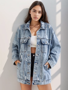 Detail of light wash oversized denim jacket featuring distressed rips and classic lapel