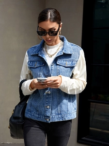 Detail of denim jacket featuring blue denim vest and cream corduroy sleeves patchwork
