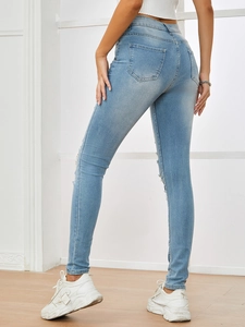Rear view of slim fit high-waisted distressed light blue jeans with ripped leg detail