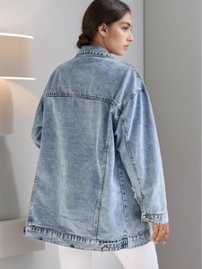Detail of light blue denim jacket showing back stitching and vintage washed texture