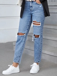 Detailed close-up of distressed light blue high-waisted denim jeans with ripped knee details