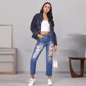 Giacca di jeans nera slavata da donna con top bianco corto e jeans blu strappati