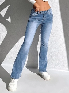 Jean évasé bleu clair délavé vintage avec effet d'ombre artistique sur mur blanc