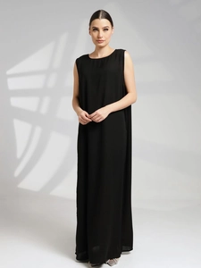 Détail d'une robe longue noire sans manches à col rond avec une coupe ample et élégante
