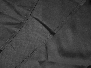 Détail rapproché des coutures doubles sur un tissu tissé noir de haute qualité