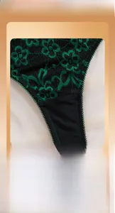 Gros plan sur la broderie de dentelle florale noire et verte sur lingerie de femme