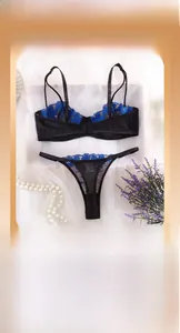 Détail de broderie florale bleue sur ensemble de lingerie en mesh noir avec perles