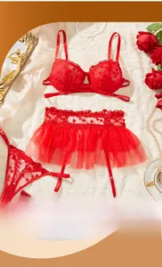 Dettaglio del set lingerie in pizzo rosso con ricamo a cuore su sfondo in peluche bianco